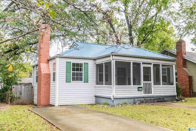 view of front facade with a front lawn and a sunroom