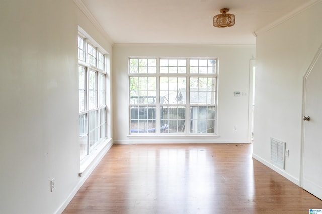 empty room featuring ornamental molding and light hardwood / wood-style floors