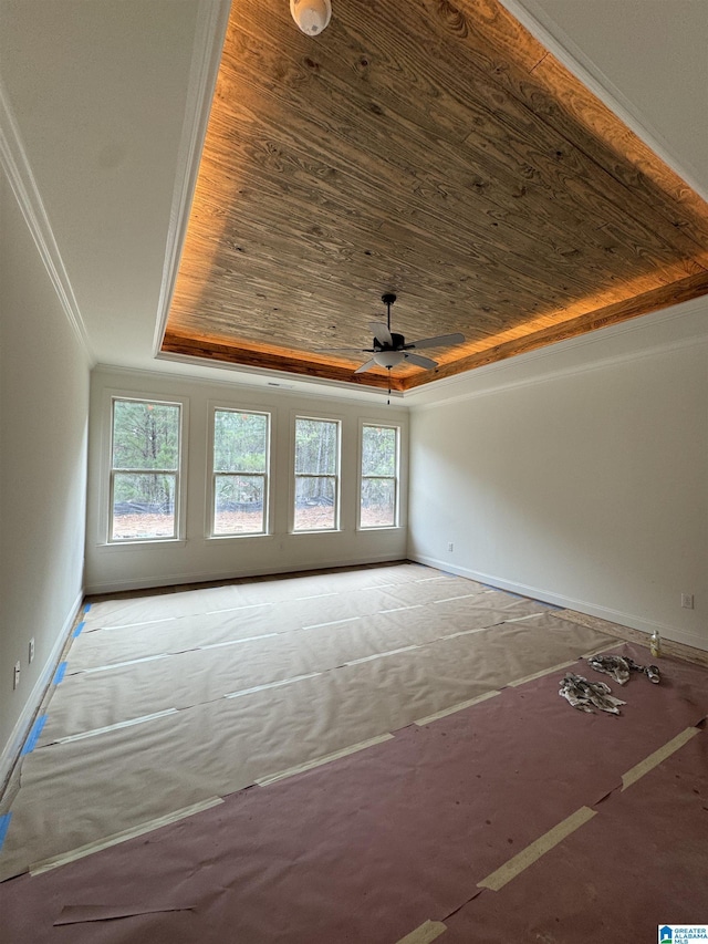 interior space featuring wood ceiling, a tray ceiling, a wealth of natural light, and ornamental molding