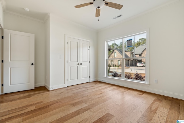 unfurnished bedroom featuring ceiling fan, ornamental molding, a closet, and light hardwood / wood-style flooring