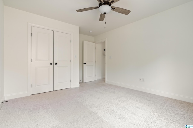 unfurnished bedroom with ceiling fan, light colored carpet, and a closet