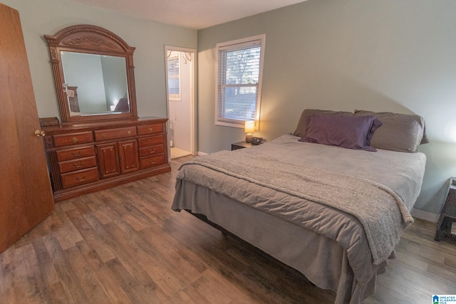 bedroom featuring ensuite bathroom and hardwood / wood-style floors