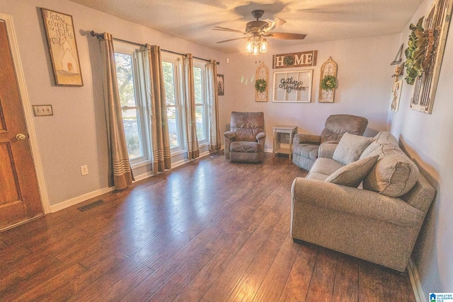 living room featuring ceiling fan and dark wood-type flooring