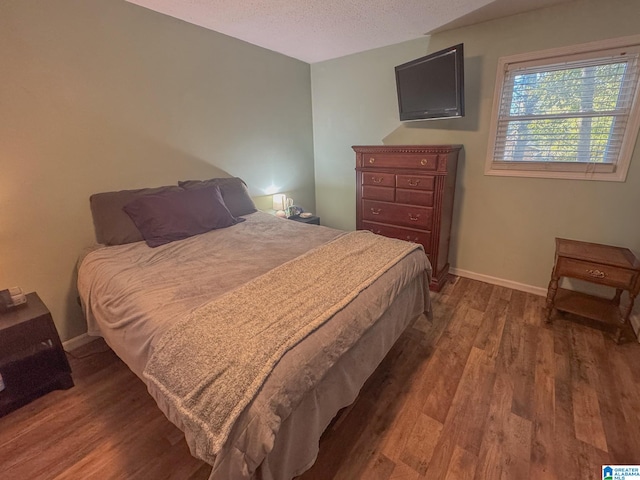 bedroom featuring dark wood-type flooring and a textured ceiling