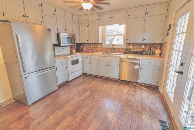 kitchen featuring sink, hardwood / wood-style flooring, ceiling fan, backsplash, and stainless steel appliances