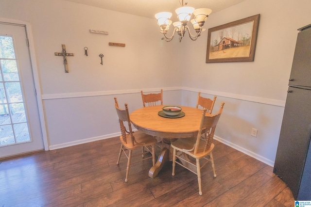 dining space with dark wood-type flooring and a notable chandelier