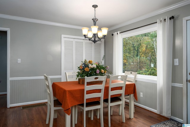 dining room with ornamental molding, an inviting chandelier, dark hardwood / wood-style floors, and plenty of natural light