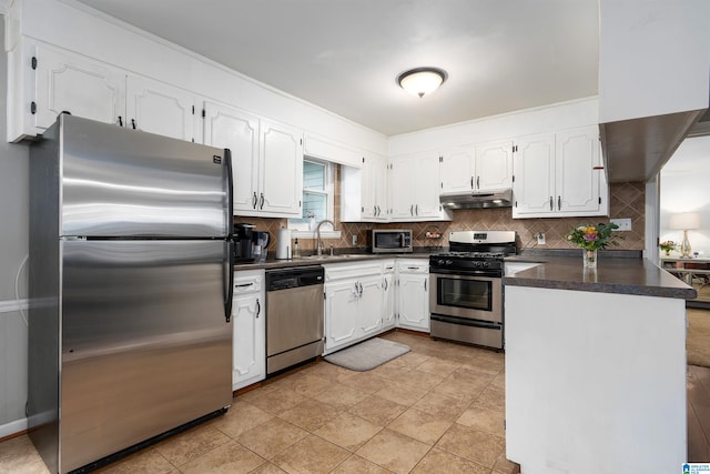 kitchen featuring sink, kitchen peninsula, appliances with stainless steel finishes, tasteful backsplash, and white cabinets