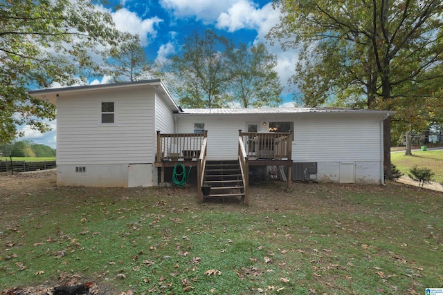 rear view of property with a deck, central AC unit, and a yard