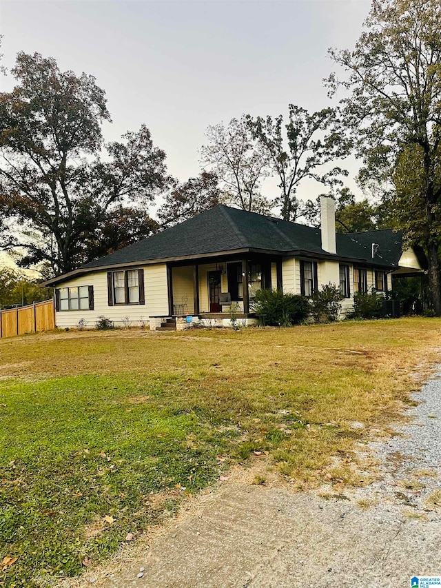 single story home with covered porch and a front yard