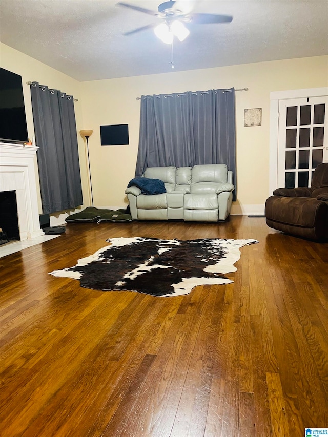 unfurnished living room with hardwood / wood-style floors, ceiling fan, and a tile fireplace