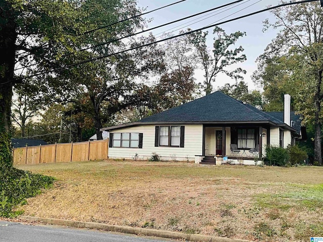 view of front of home with covered porch and a front lawn