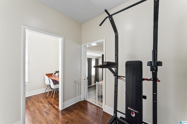 workout area with a textured ceiling and dark hardwood / wood-style floors