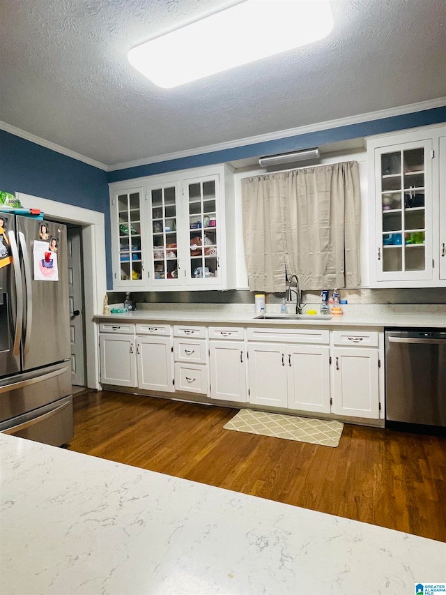 kitchen featuring appliances with stainless steel finishes, dark hardwood / wood-style floors, white cabinetry, and sink