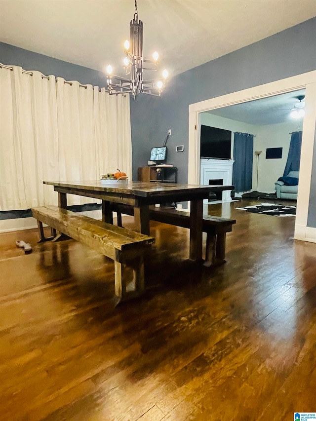 dining area with dark hardwood / wood-style floors and an inviting chandelier