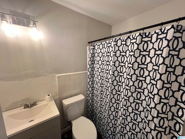 bathroom featuring tile walls, a shower with curtain, vanity, a textured ceiling, and toilet