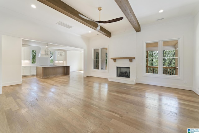 6558 Deerfoot Crossing Rd, Trussville, AL 35173 - unfurnished living room with ceiling fan, beam ceiling, light wood-style flooring, baseboards, and a brick fireplace