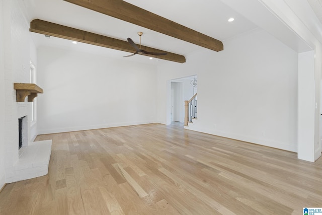 6558 Deerfoot Crossing Rd, Trussville, AL 35173 - unfurnished living room with ceiling fan, a brick fireplace, light wood-style floors, stairs, and beamed ceiling