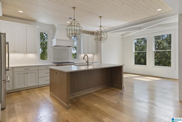 6558 Deerfoot Crossing Rd, Trussville, AL 35173 - kitchen with a sink, custom exhaust hood, wood ceiling, plenty of natural light, and decorative backsplash