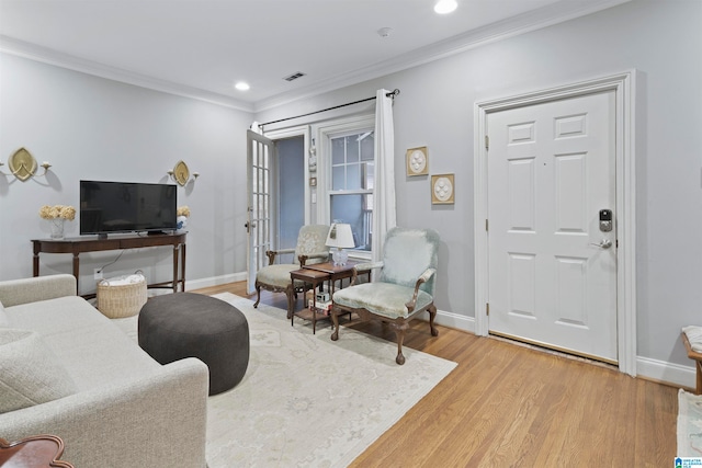 living room with light hardwood / wood-style floors and crown molding