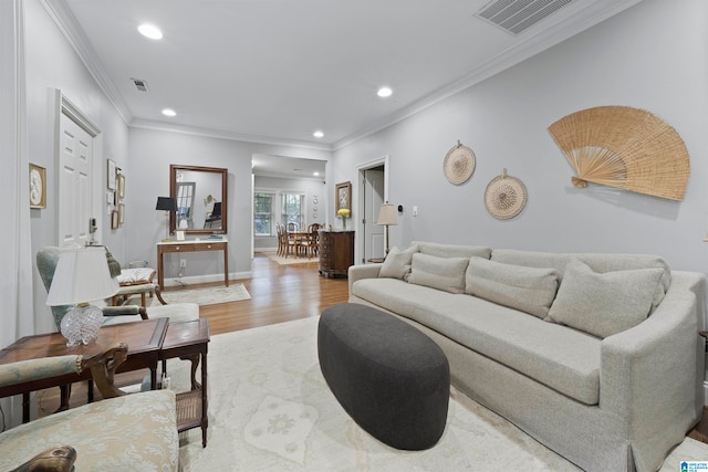 living room with light hardwood / wood-style floors and crown molding