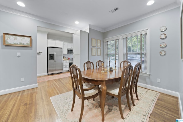 dining room featuring light wood-type flooring and ornamental molding