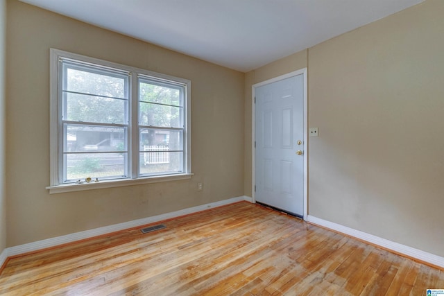 spare room with plenty of natural light and light hardwood / wood-style flooring