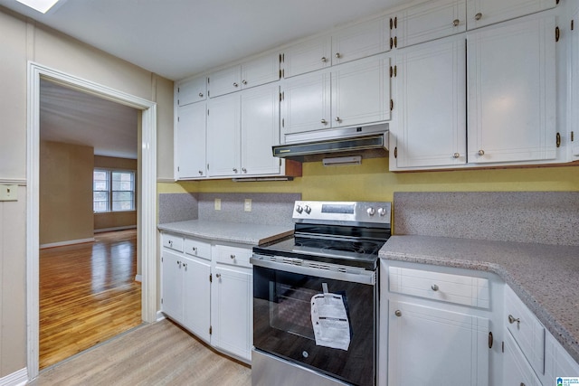 kitchen with white cabinets, light hardwood / wood-style floors, and stainless steel electric range