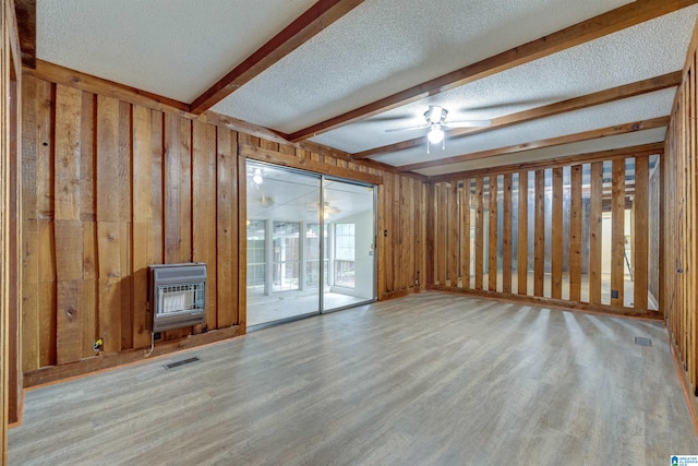 interior space featuring light hardwood / wood-style flooring, wood walls, and heating unit