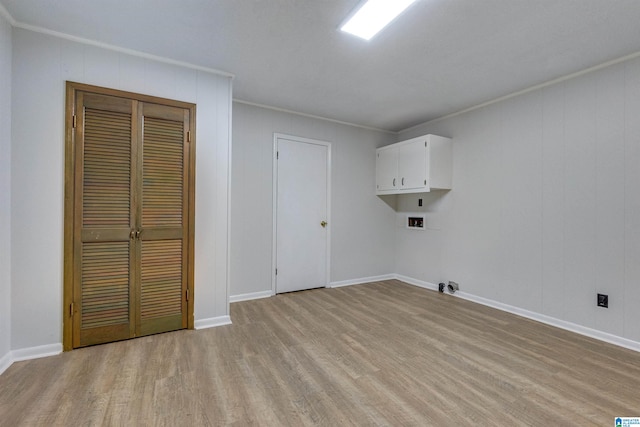 laundry room with ornamental molding, light wood-type flooring, washer hookup, and cabinets