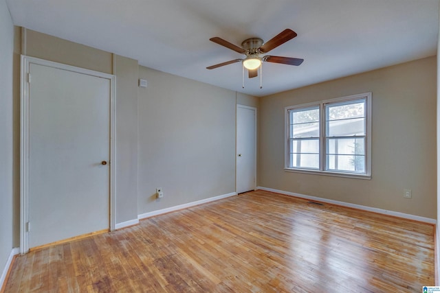 empty room with ceiling fan and light hardwood / wood-style flooring