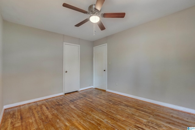 empty room with ceiling fan and light hardwood / wood-style flooring