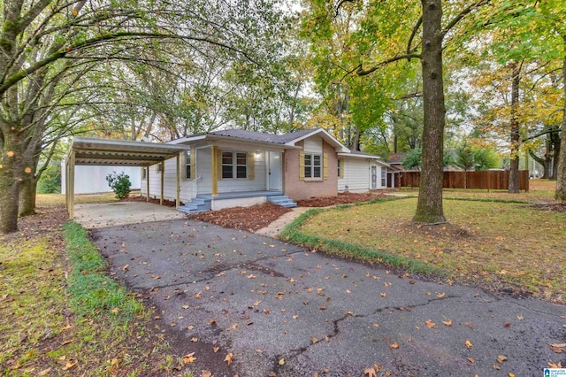 view of front of property featuring a carport, covered porch, and a front yard