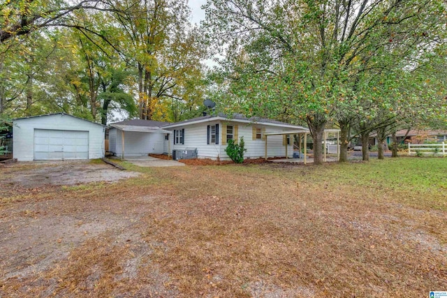 ranch-style house featuring a garage, a front yard, and an outbuilding