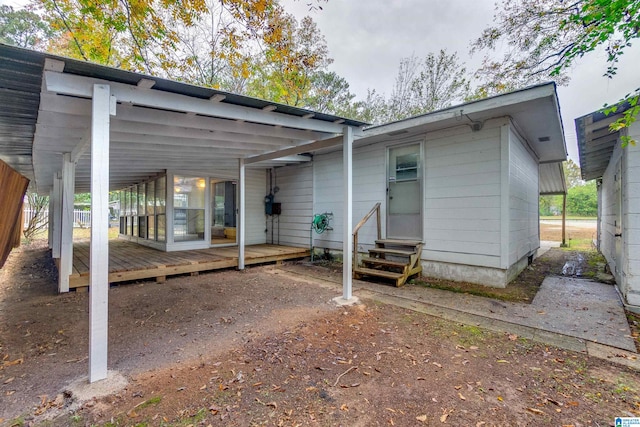 back of house with a deck and a carport