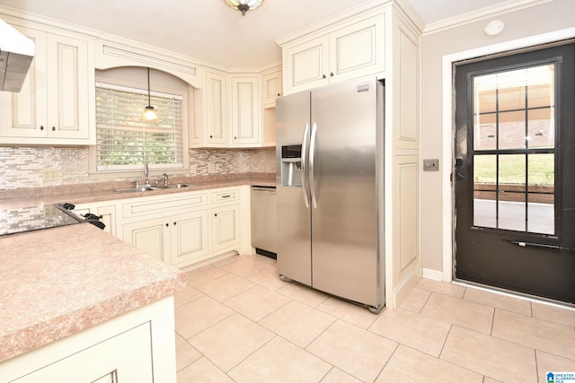 kitchen with appliances with stainless steel finishes, tasteful backsplash, decorative light fixtures, and light tile patterned floors