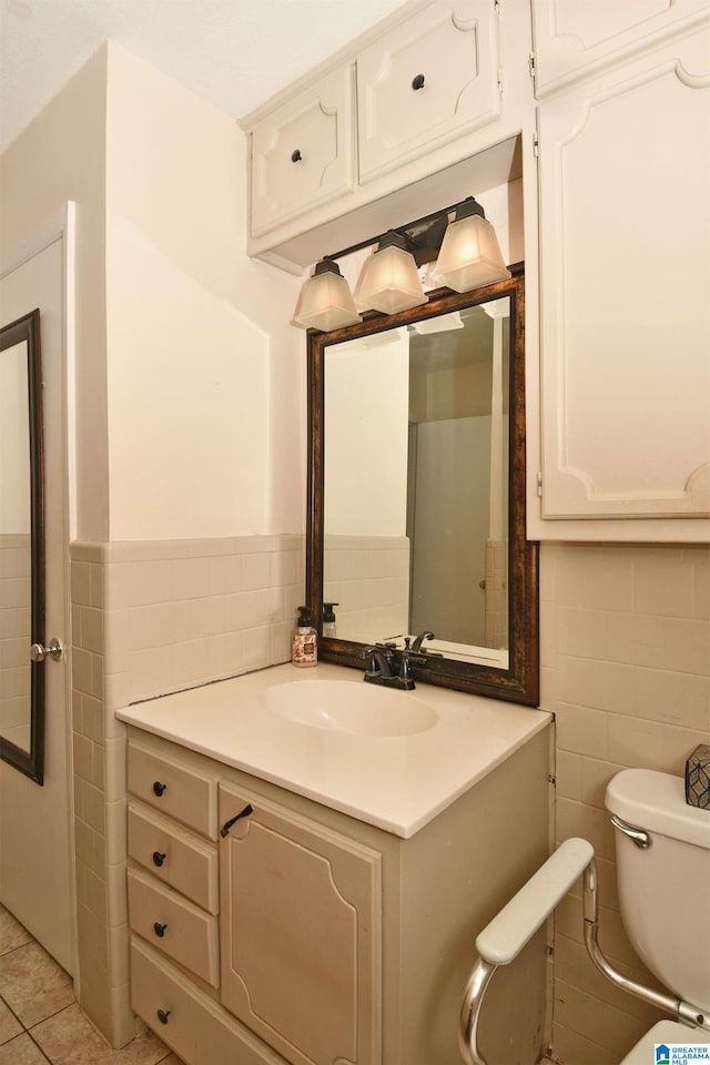 bathroom featuring toilet, vanity, tile walls, and tile patterned floors