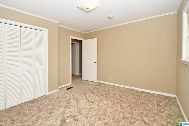 unfurnished bedroom with light carpet, crown molding, and a closet