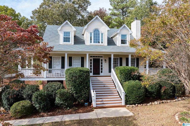 cape cod home featuring covered porch