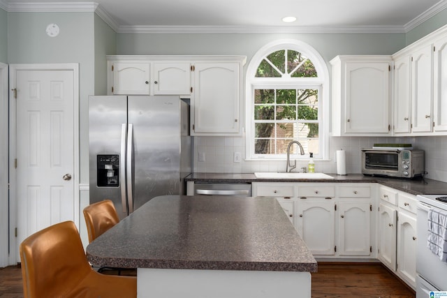 kitchen featuring sink, appliances with stainless steel finishes, tasteful backsplash, dark hardwood / wood-style floors, and white cabinets