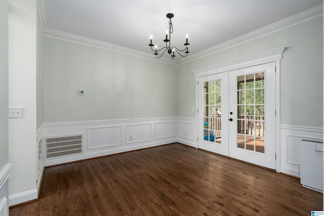 spare room with french doors, dark hardwood / wood-style flooring, a notable chandelier, and crown molding