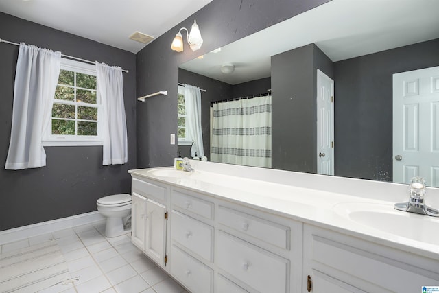 bathroom featuring toilet, vanity, and tile patterned flooring