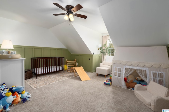 carpeted bedroom featuring vaulted ceiling, ceiling fan, and a crib