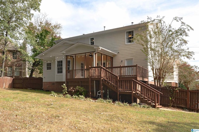 rear view of house featuring a lawn and a wooden deck