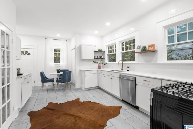 kitchen with white cabinetry, stainless steel dishwasher, sink, and backsplash