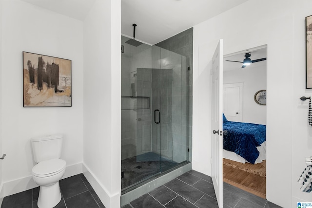 bathroom featuring ceiling fan, a shower with door, tile patterned floors, and toilet