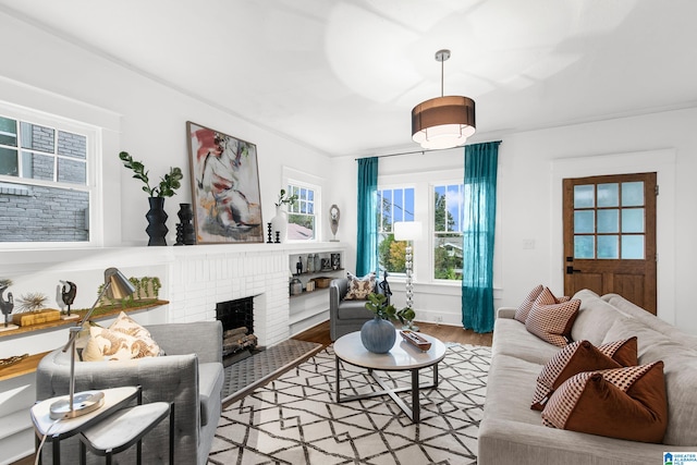 living room featuring a brick fireplace and hardwood / wood-style flooring