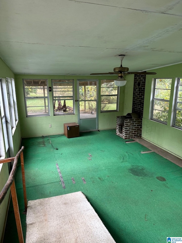 unfurnished sunroom featuring ceiling fan