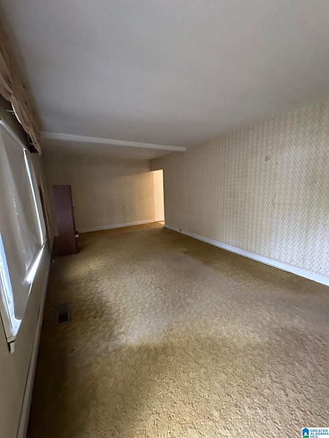 spare room featuring dark colored carpet