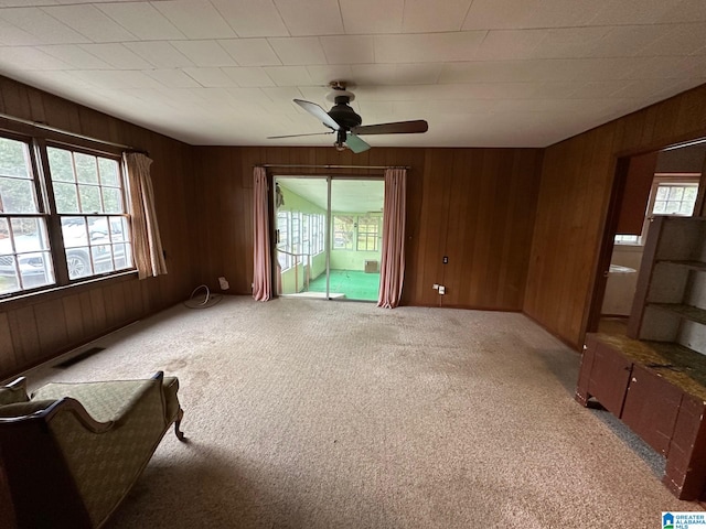 interior space with wooden walls and ceiling fan